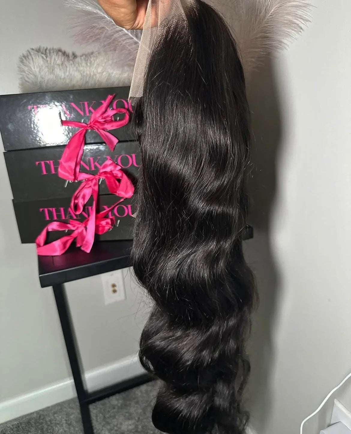 Glam Luxe Hair Collection virgin body wave hair extensions in natural black with soft, flowing waves.